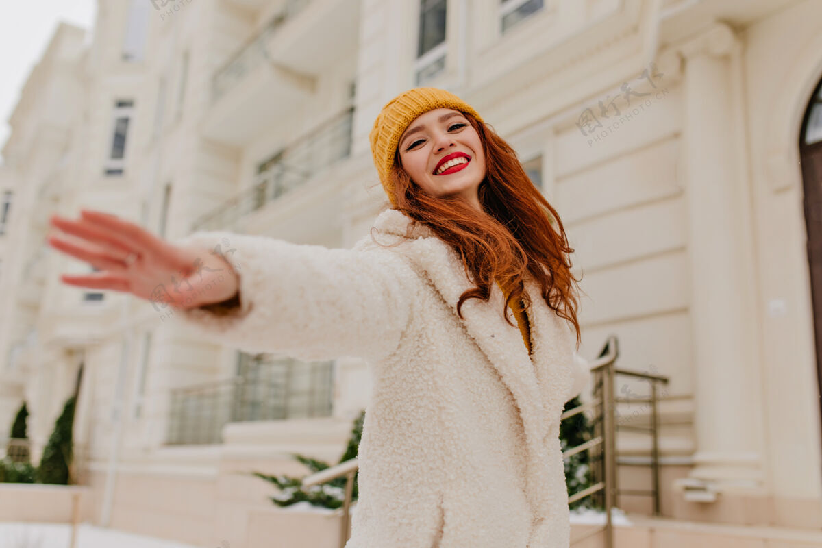 年轻女子情绪化的姜汁女孩 穿着冬装 微笑着摆姿势可爱的红发女人的户外肖像 脸上洋溢着幸福的表情外套街道欧洲