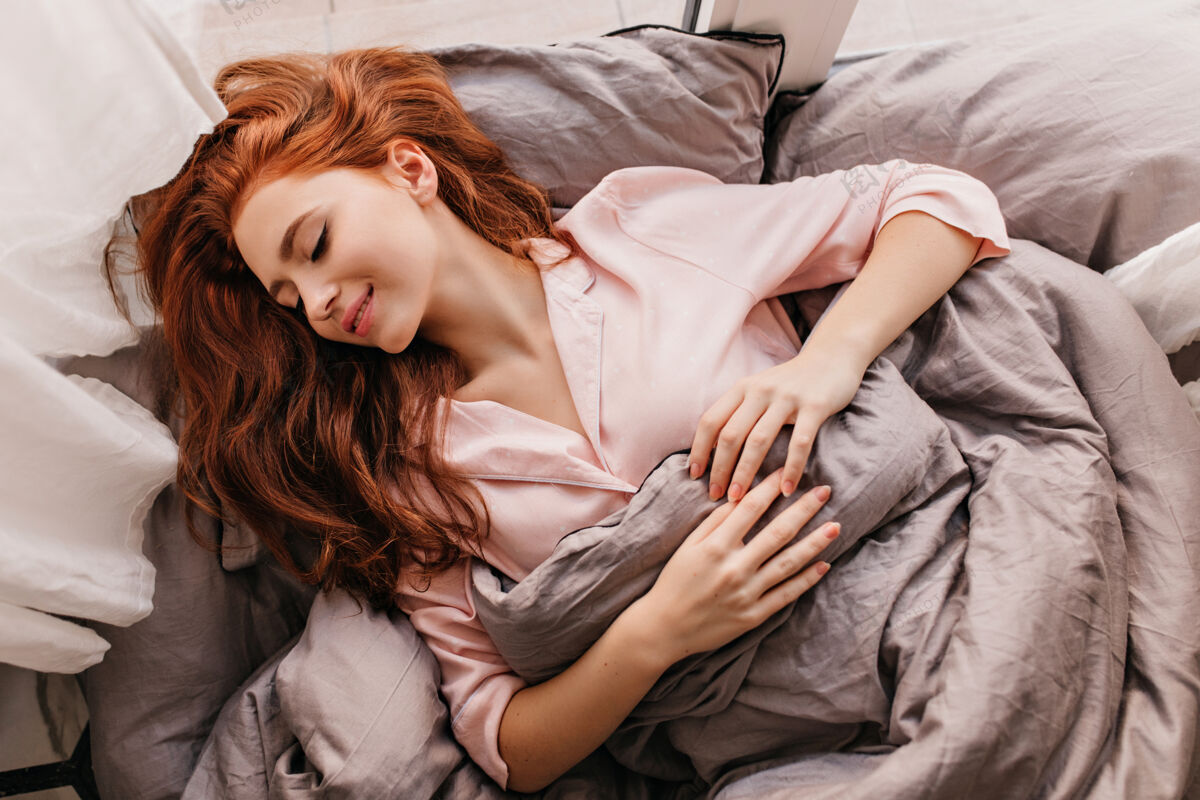 公寓迷人的长发女人睡在早上姜女孩躺在床上的灵感表情红发欧洲