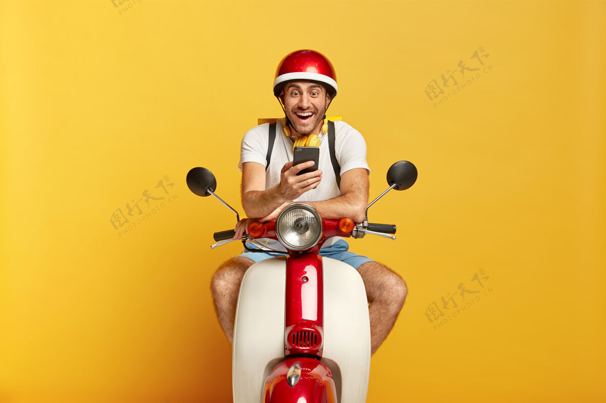 集中快乐英俊的男司机骑着红色头盔的摩托车骑摩托车车辆