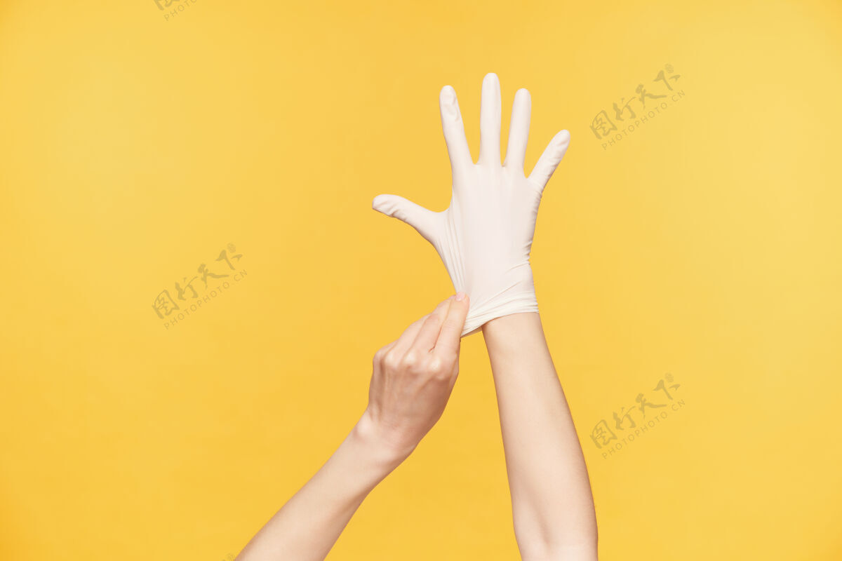 庄稼摄影棚照片中 年轻女子举起的手在橙色背景上摆姿势 保持所有手指分开 同时另一只手戴上白色橡胶手套手臂女性举