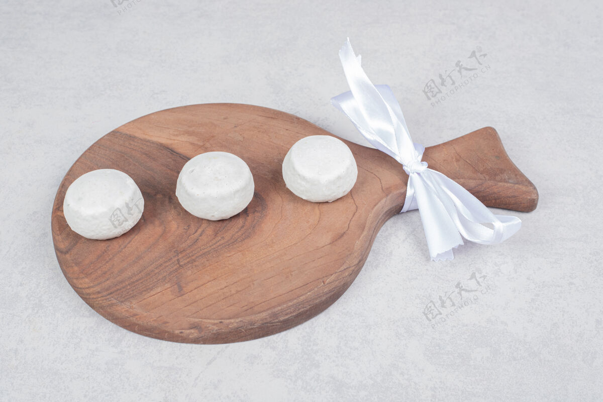可食用三个甜饼和白色蝴蝶结在木板上高品质的照片姜饼好吃吃