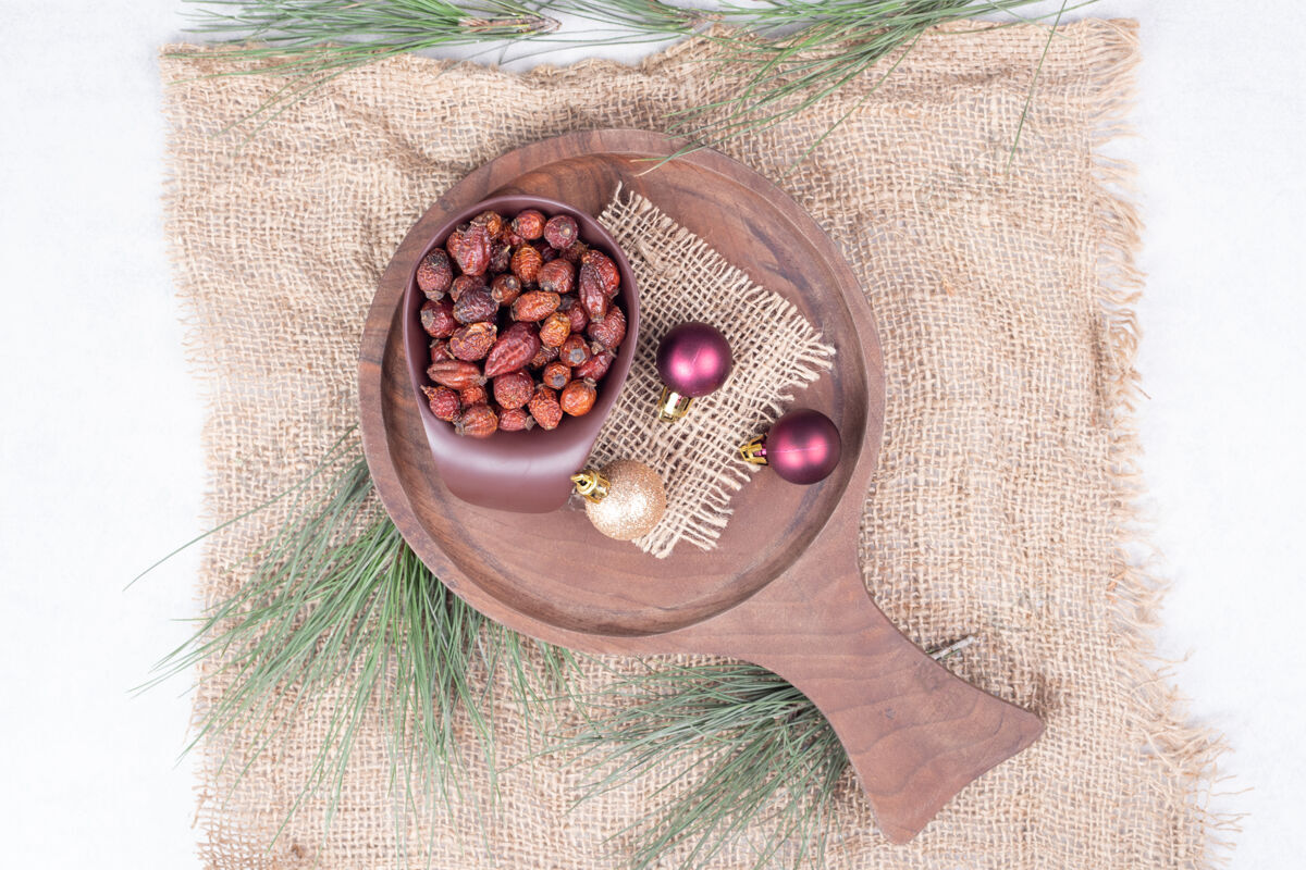 球一碗干蔓越莓和圣诞球在木板上高品质的照片水果粗麻布可食用