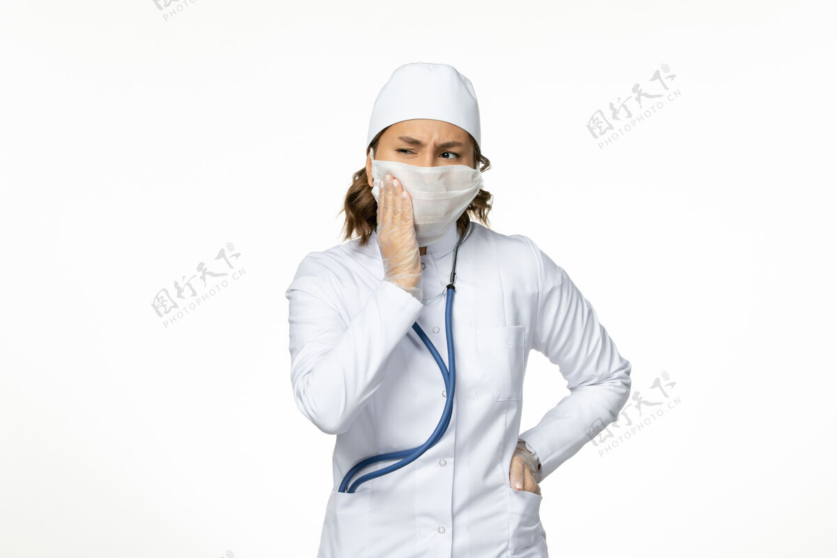 到期正面图年轻女医生戴着无菌防护口罩因白色书桌上有冠状病毒消毒病毒大流行