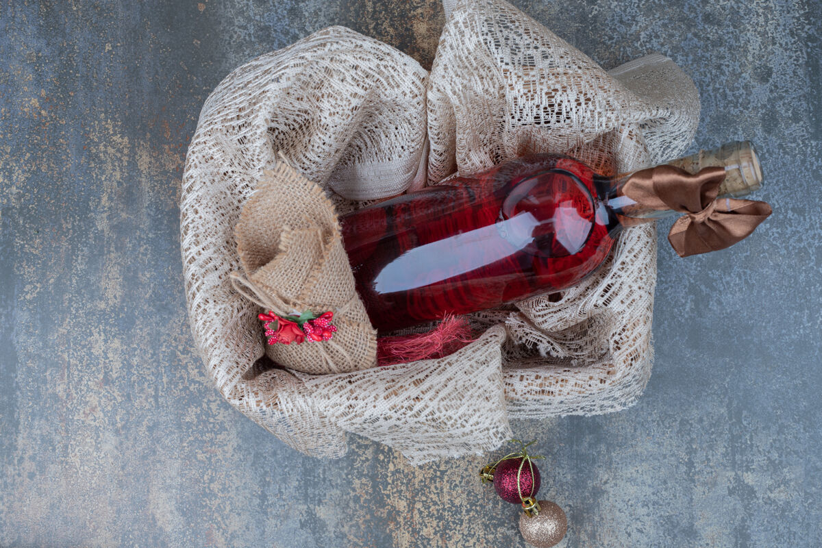 篮子一瓶用彩带装饰的葡萄酒放在木篮里高质量的照片圣诞节红色瓶子