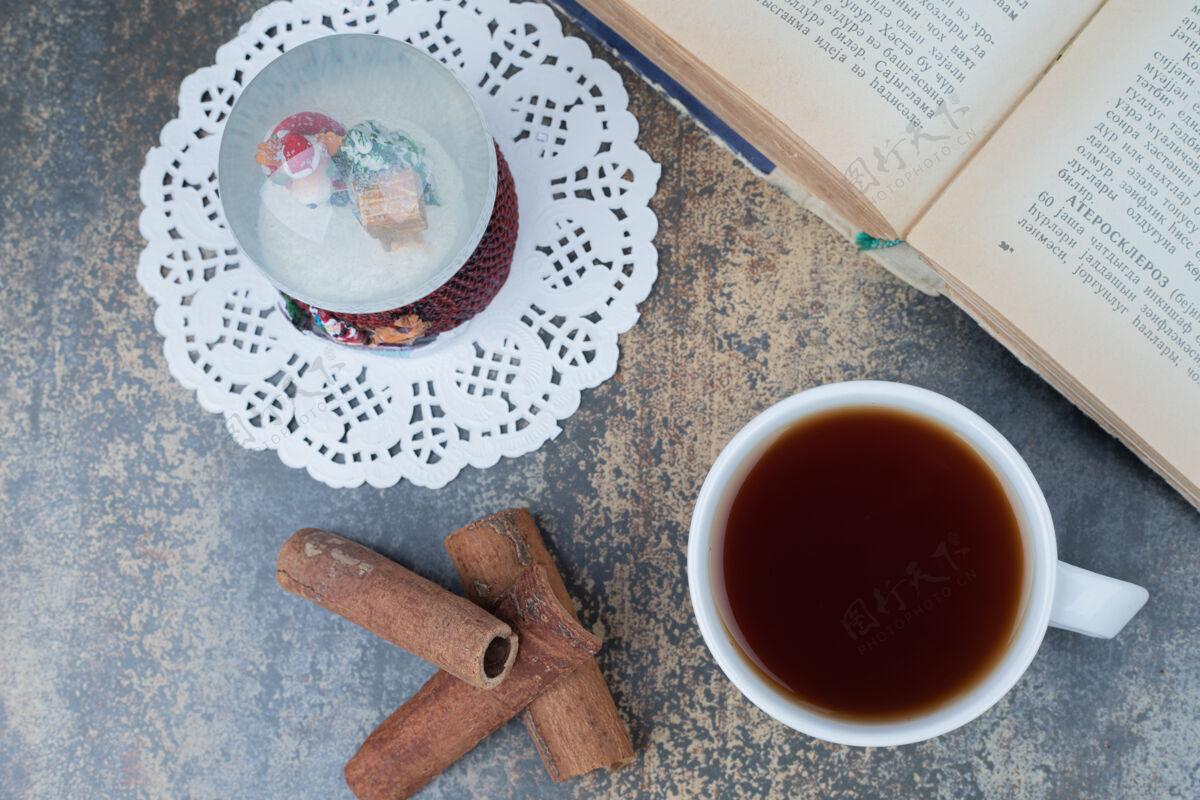 茶圣诞地球仪 一杯茶和打开大理石表面的书高品质的照片夏娃饮料杯子