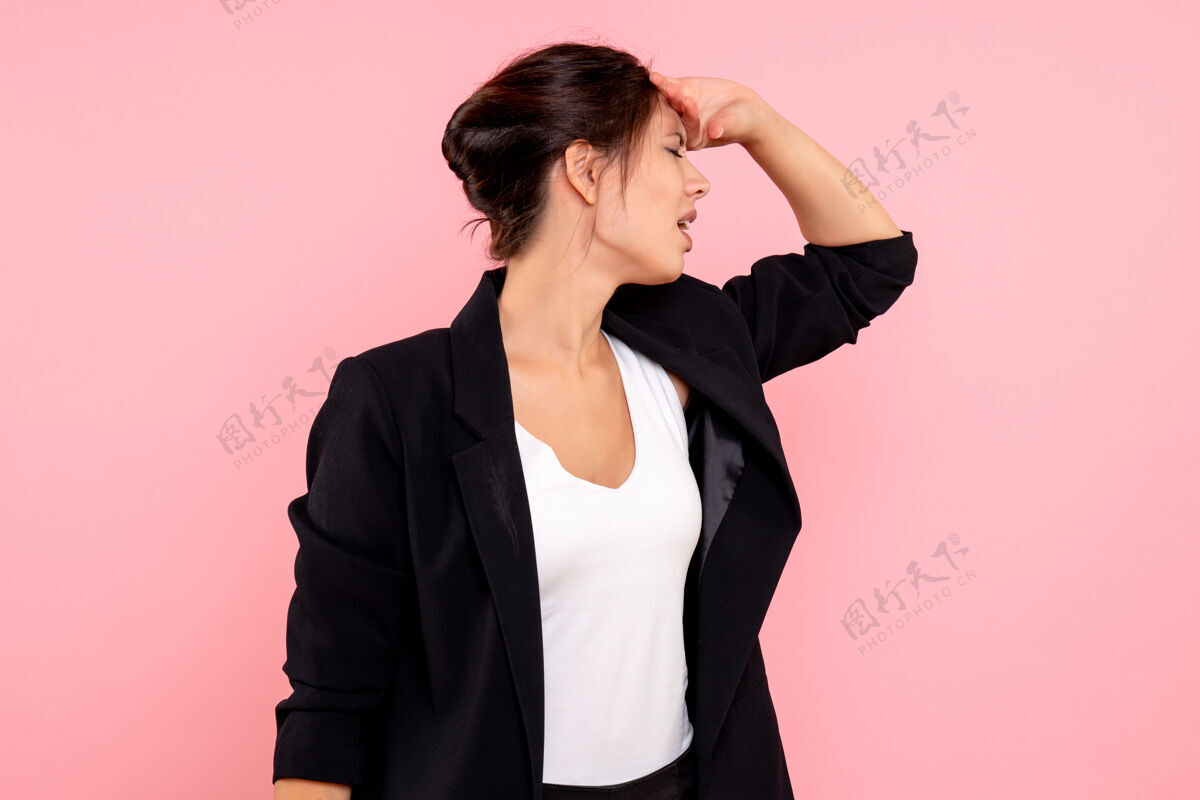 夹克正面图：穿着深色夹克的年轻女性 强调粉色背景情感视图年轻女性