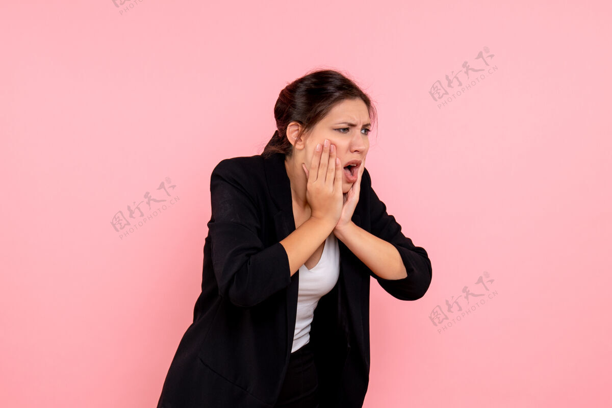 年轻女性正面图粉色背景上穿着深色夹克 牙痛的年轻女性深色牙痛情感