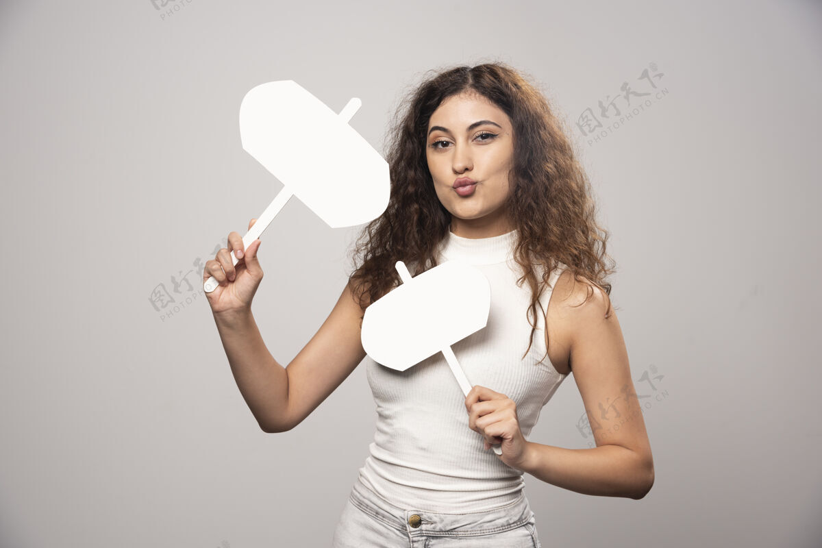 年轻年轻女子拿着两张白色的空白海报高质量的照片人头发漂亮
