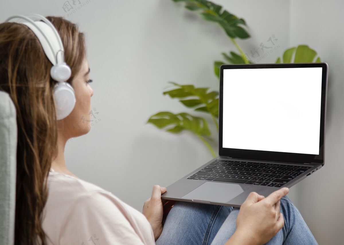 女人侧视图：戴耳机的女士使用笔记本电脑设备黑屏笔记本电脑