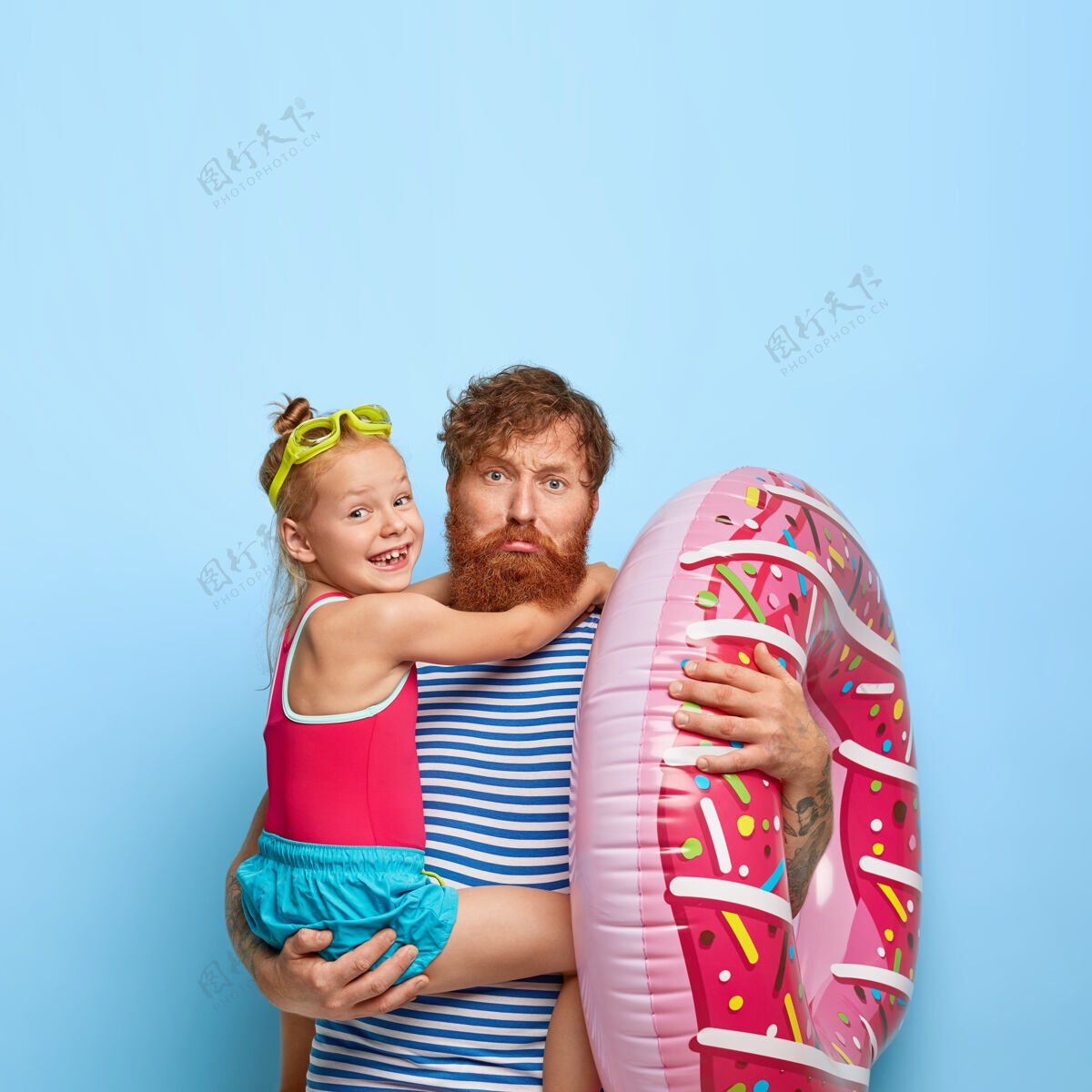 橡胶悲伤疲惫的父亲 姜黄色胡须 手抱小女儿 充气游泳 一起去海滩 穿着休闲 在休息的地方娱乐悲伤娱乐纹身