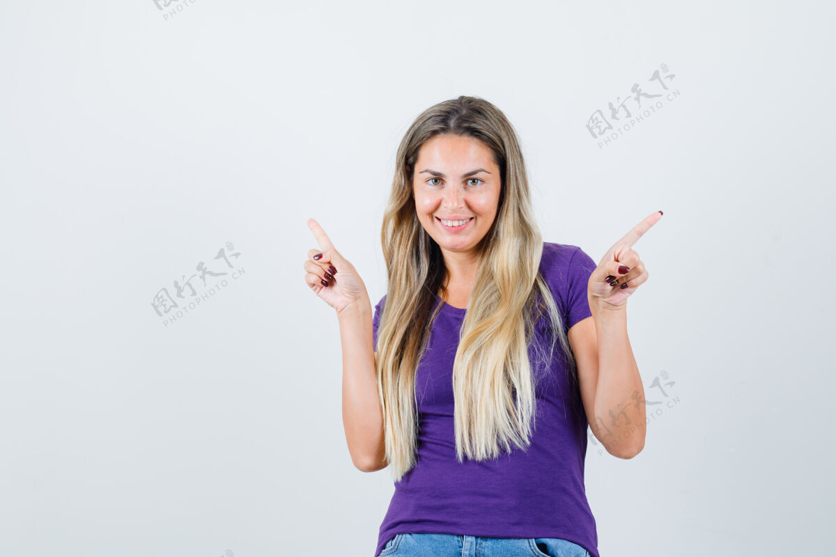 人穿着紫色t恤的年轻女性指着不同的侧面 愉快地看着前视图指向紫罗兰看