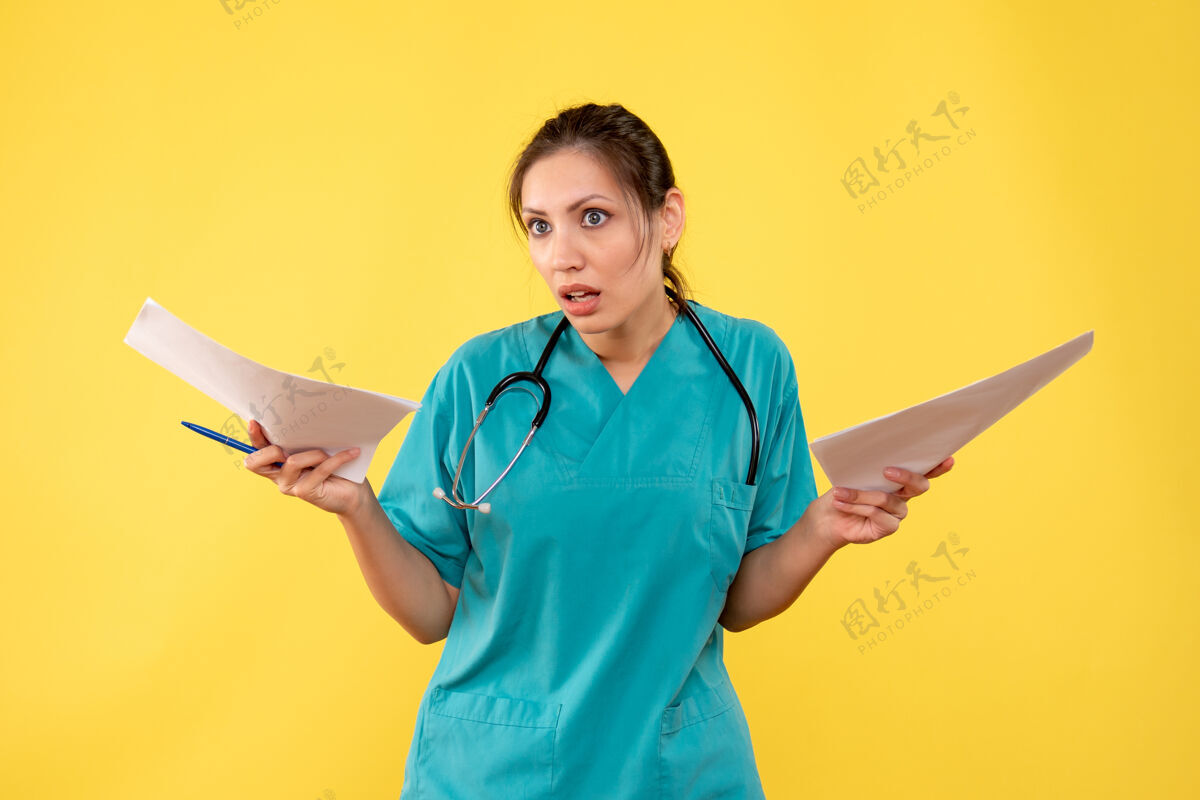 黄正面图年轻女医生穿着医用衬衫拿着黄色背景的纸张分析纸持医学