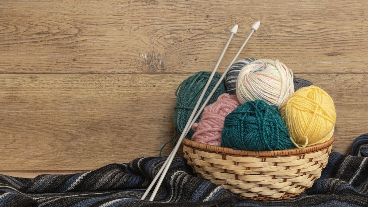 材料毛线和编织针放在篮子里顶视图面料篮子