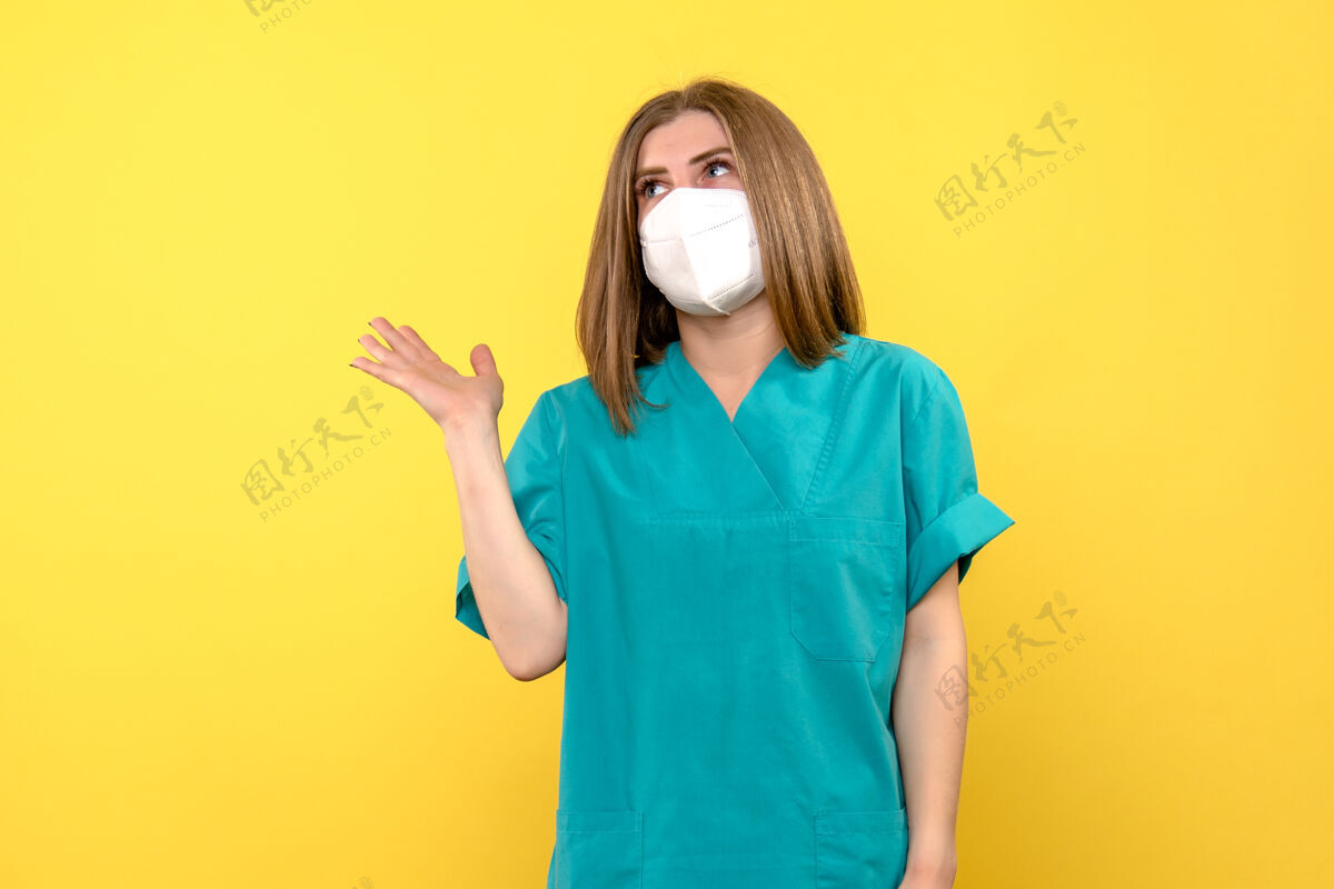 穿着黄色空间上戴面罩的女医生的正面图肖像病毒流行
