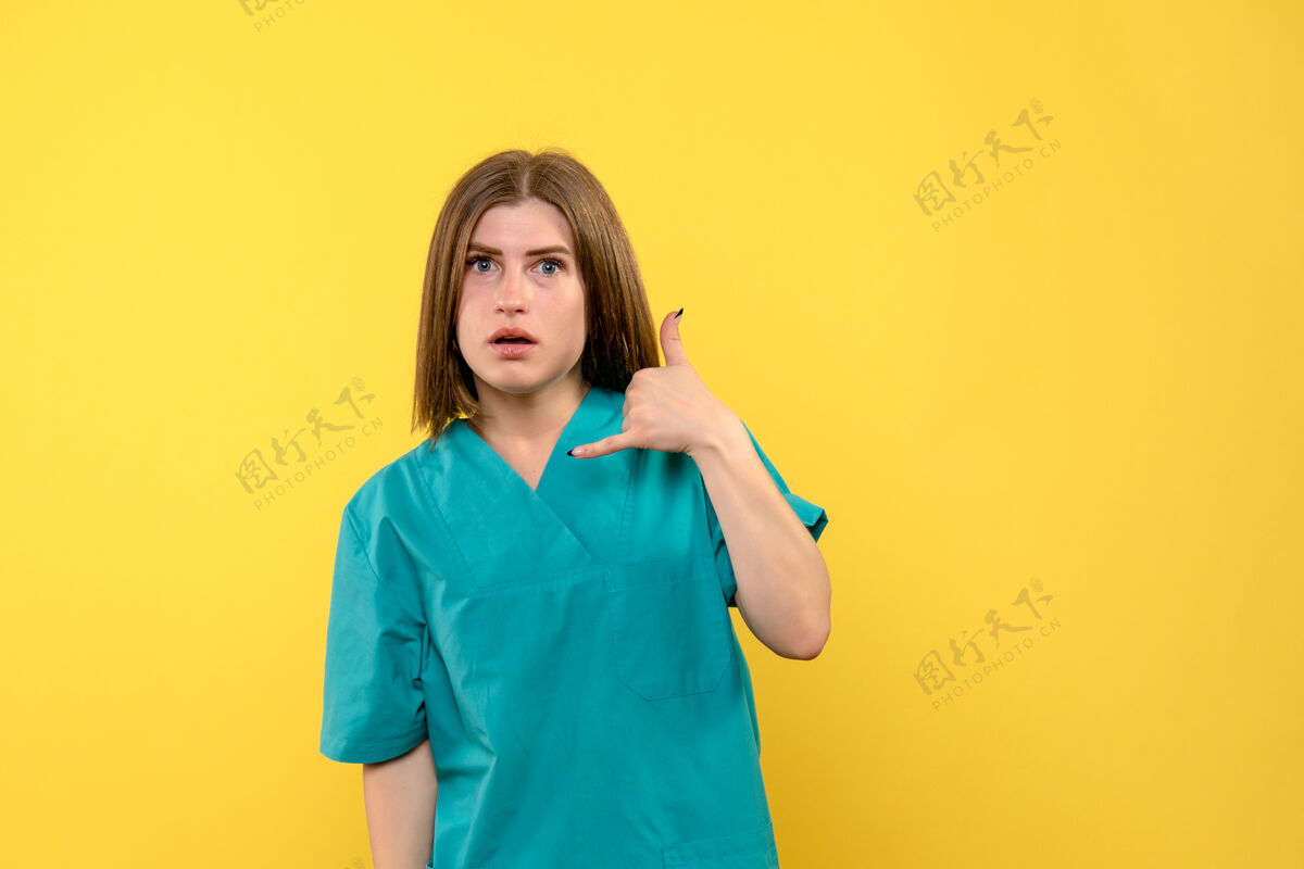 成人前视图女性医生在淡黄色空间摆姿势姿势肖像黑发