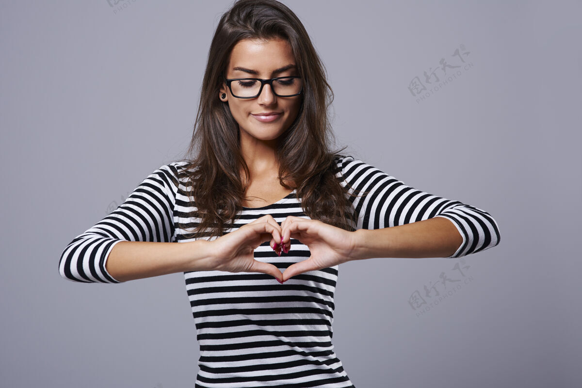 人类的手一个年轻的黑发女郎展示的心形标志手势形状心形
