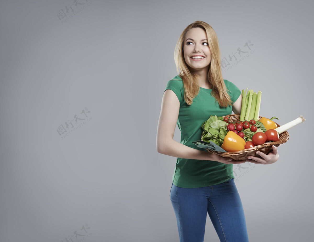 健康生活方式她在买新鲜的生态蔬菜立场番茄辣椒