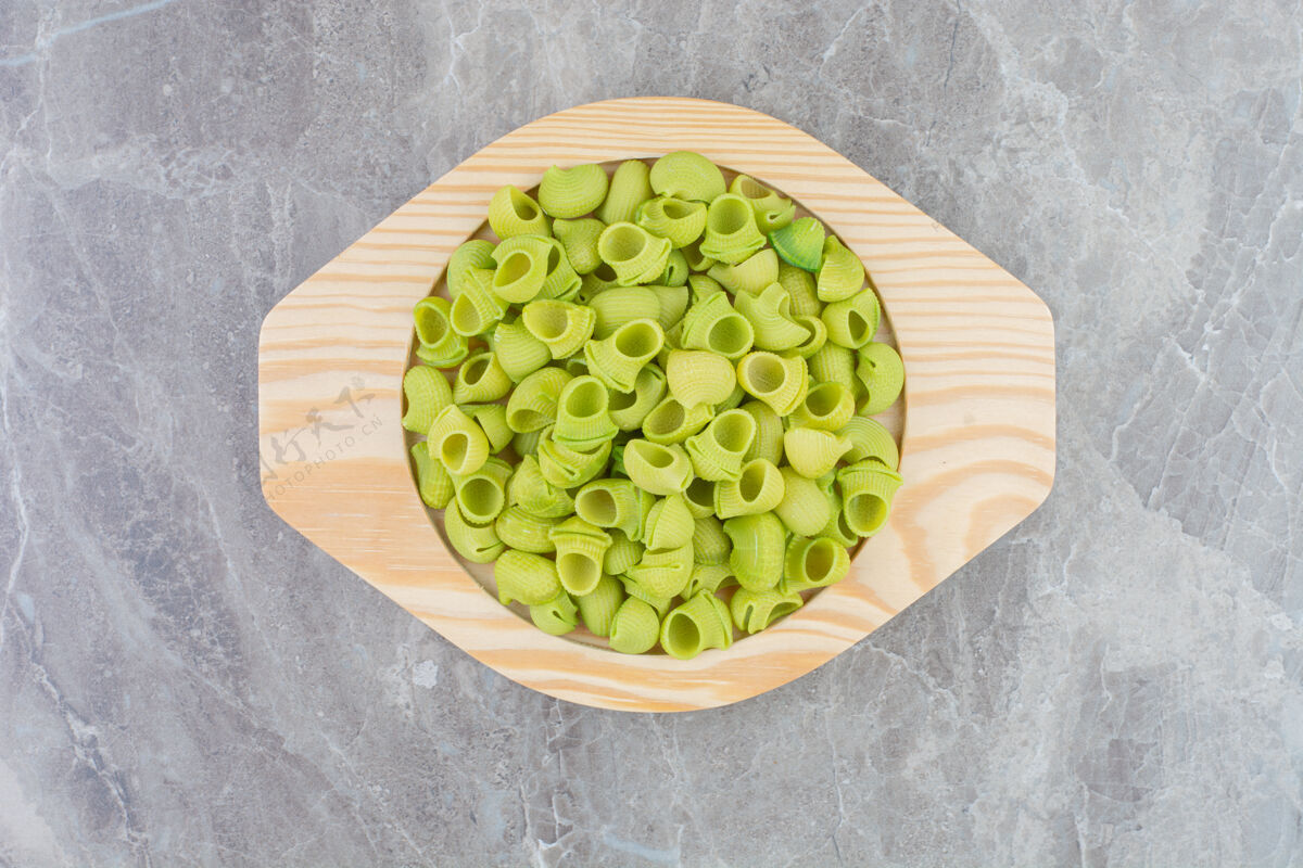 膳食在一个圆形的木制盘子里放上绿色的自制意大利面餐厅中美味