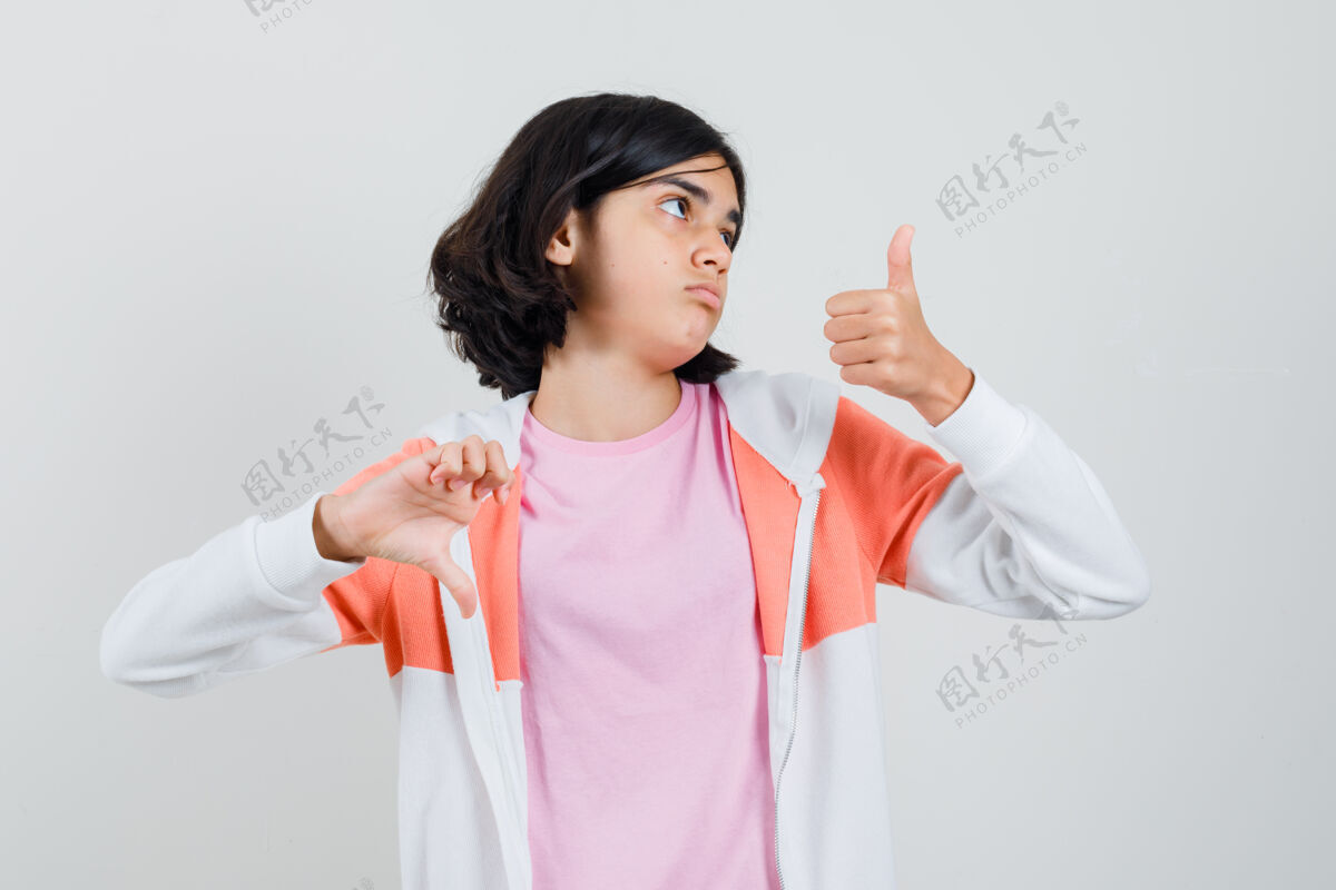 有趣穿着夹克的年轻女士 粉色衬衫上下露出大拇指 看上去很困惑时尚室内优雅