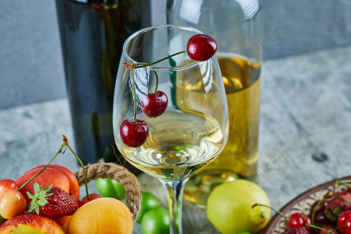 液体一桶夏天的水果 柠檬和一杯白葡萄酒放在大理石表面桶甜浆果