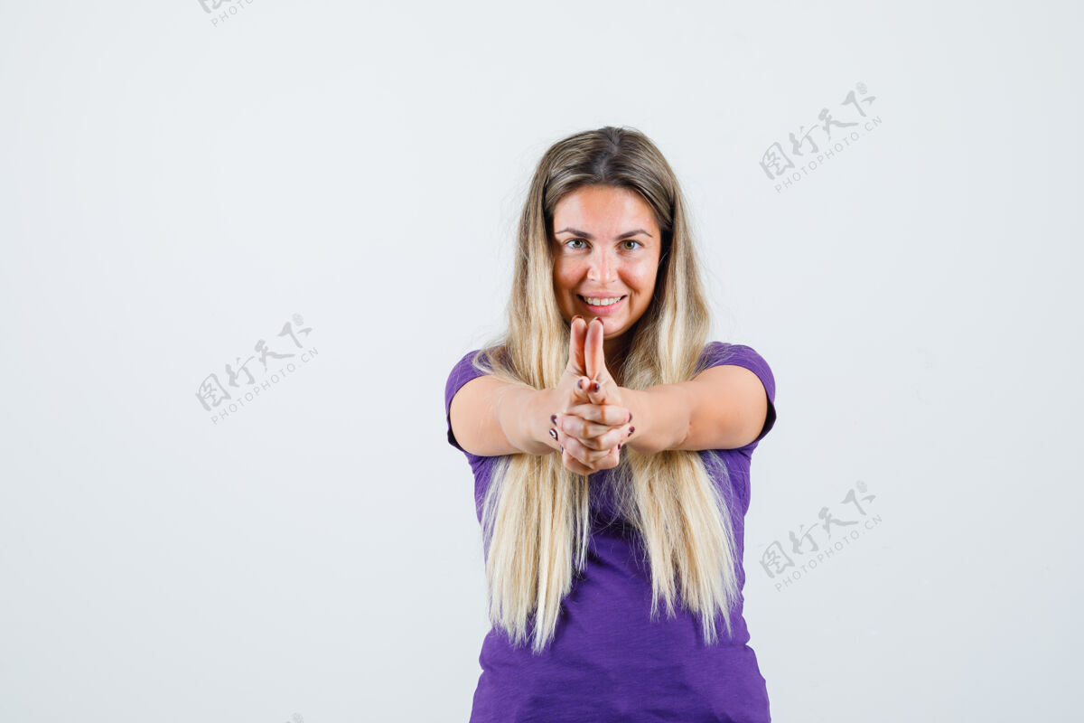 长一位金发女士身穿紫罗兰色t恤展示持枪姿势 看上去很高兴正面视图人时尚人