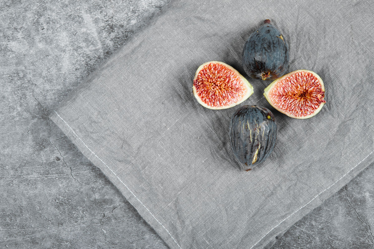 收获用灰色桌布把成熟的无花果放在大理石表面有机水果种子