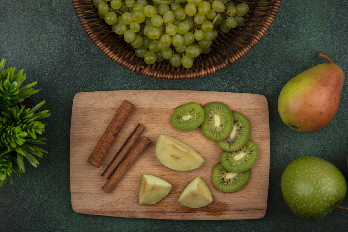 绿色俯瞰桂皮猕猴桃片 绿色背景上有绿色苹果梨和葡萄猕猴桃立场食品