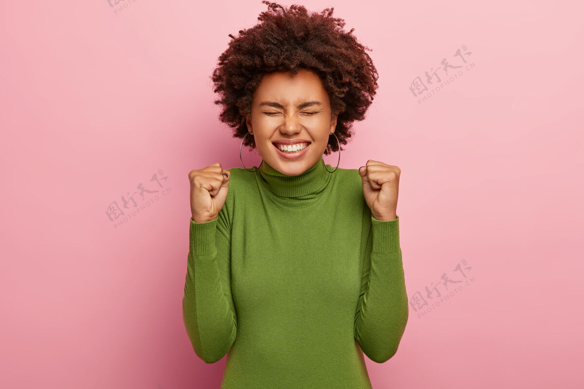 非洲喜出望外的非洲妇女胜利握拳 笑容可掬 欢庆新的成就耳环情绪积极