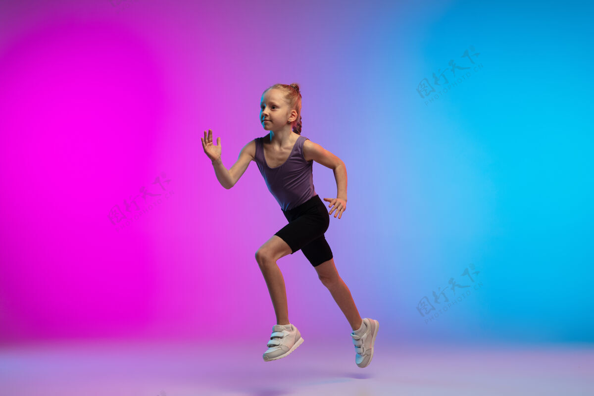 进步健康少女 专业跑步者 慢跑者 在霓虹灯下的渐变粉蓝色背景上运动隔离运动 运动 活力和动态的概念 健康的生活方式慢跑女性专业