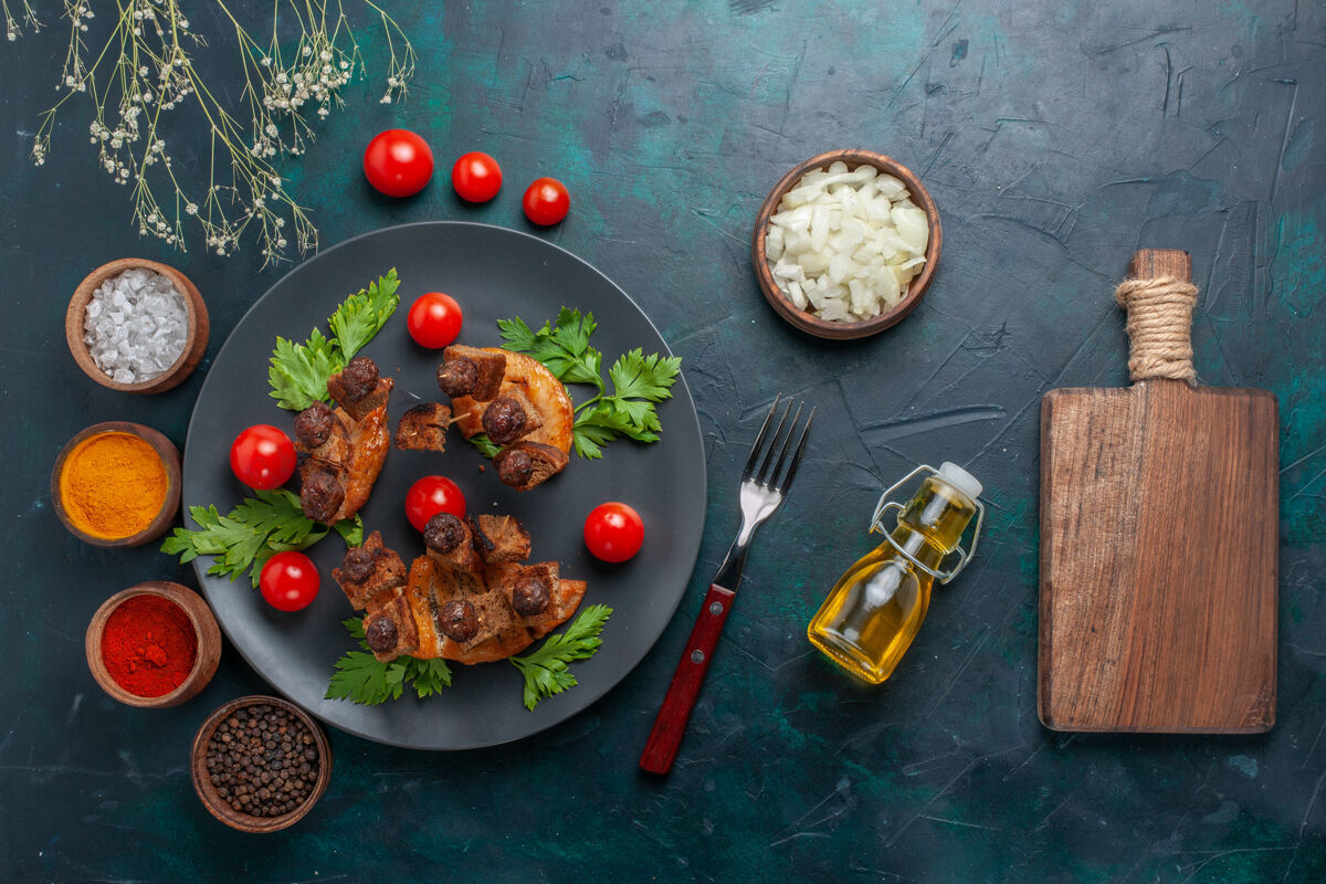 薯条顶视图橄榄油和调味料炒肉片在深蓝色桌上蔬菜食品肉类健康餐肉深蓝色油