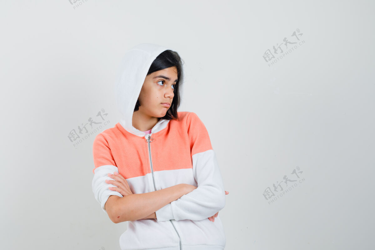 青少年十几岁的女孩交叉着双臂站在那里 穿着运动衫望着别处 满脸疑惑时尚休闲交叉