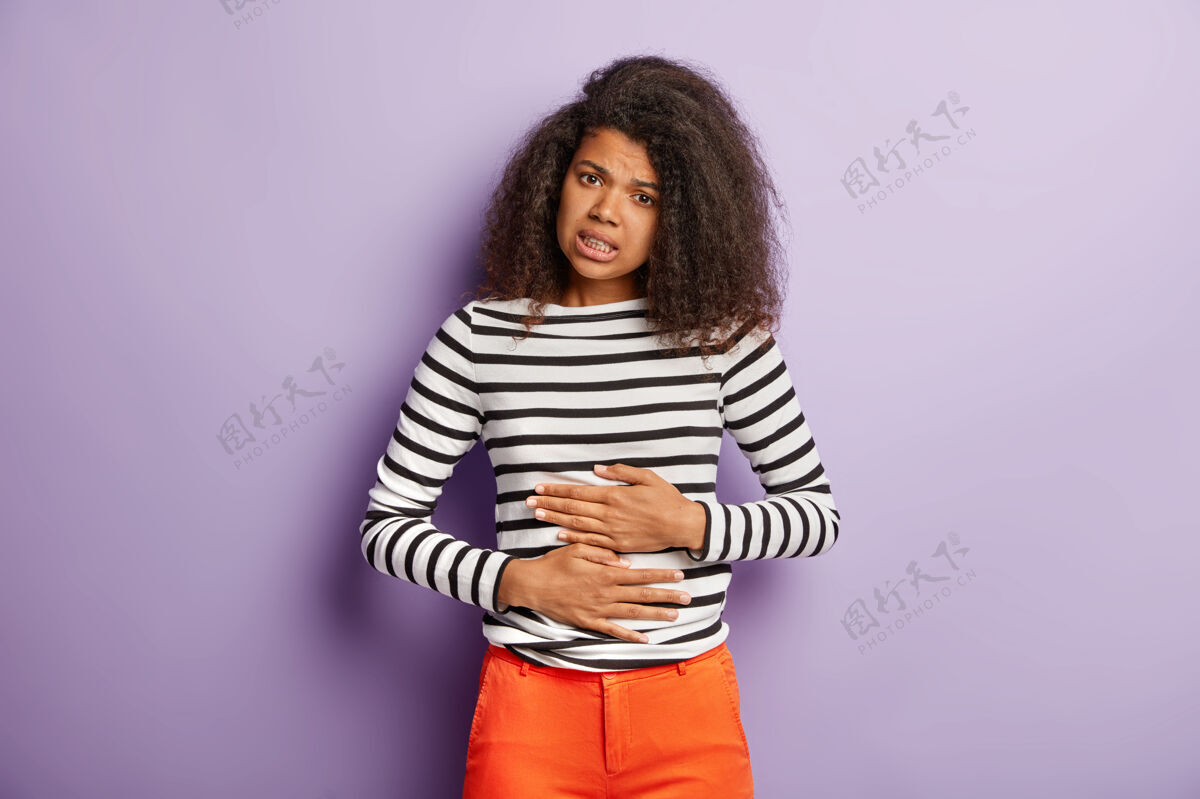 阴性不幸的美国黑人妇女摸肚子 患月经期抽筋不高兴触摸条纹