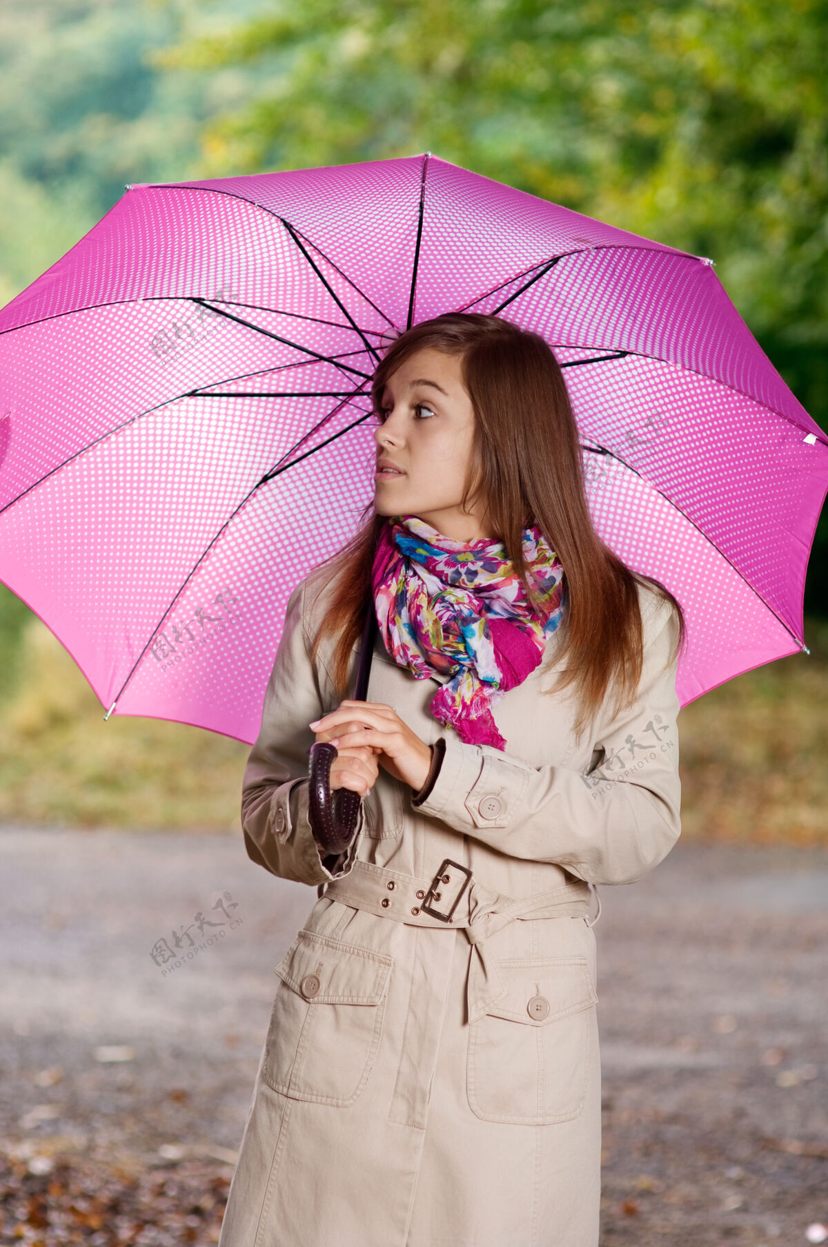 思考带伞的可爱年轻女子风衣树叶草地