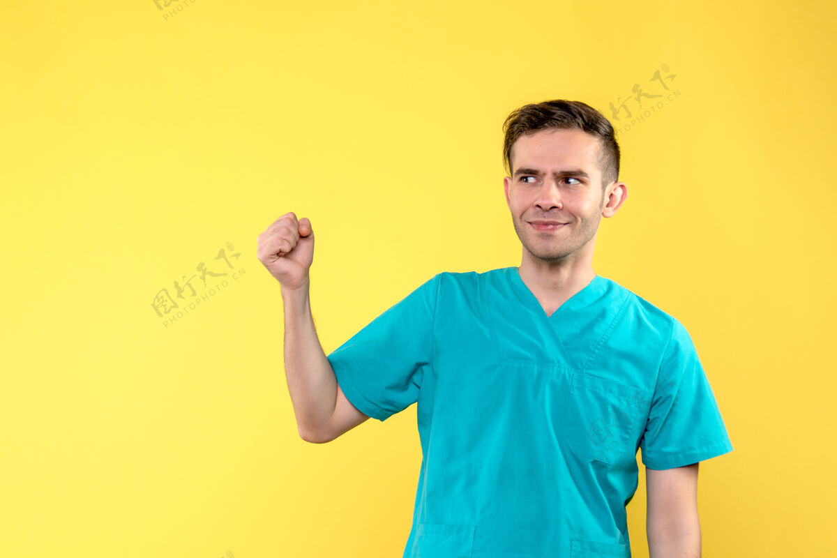 男性黄墙上的男医生脸上带着困惑的微笑医院前面情绪