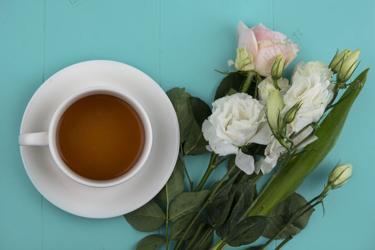 饮料一杯茶的顶视图 蓝色背景上有可爱的鲜花和树叶花爱桌子