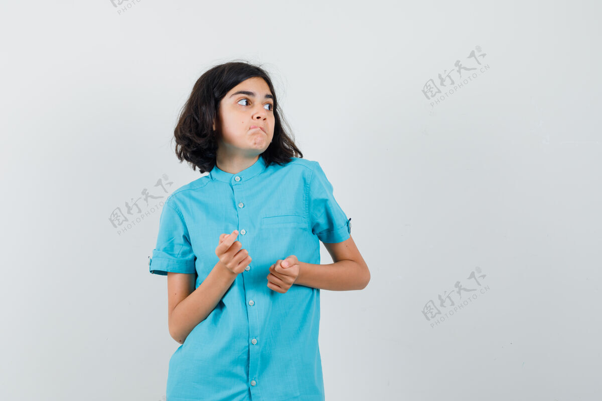 欢呼一个穿着蓝色衬衫的年轻女孩在一旁看着 看起来很兴奋时尚可爱乐趣