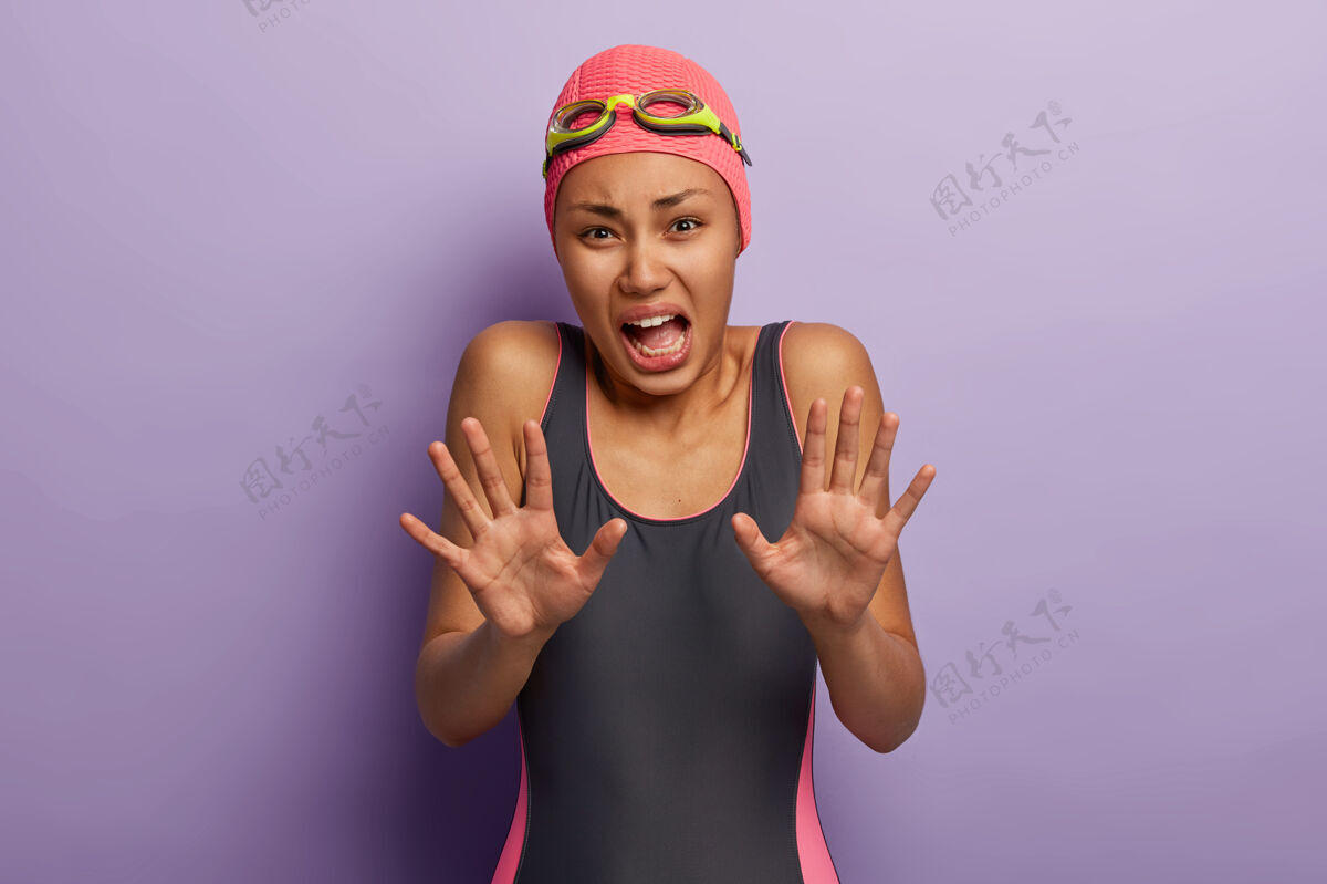 减肥忧心忡忡不满的女人向镜头拉着手 做出拒绝的手势 拒绝游泳 害怕水私人教练护目镜害怕