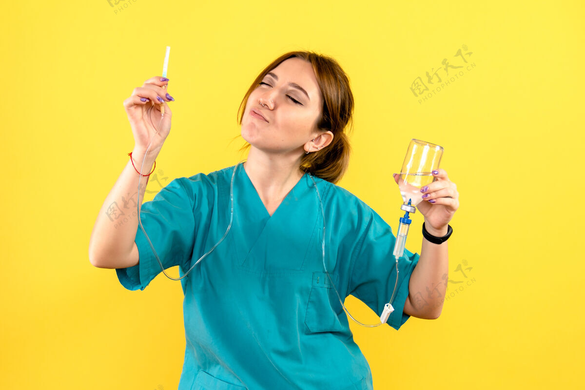 微笑黄色墙上的女兽医拿着滴管的正视图专业快乐医学