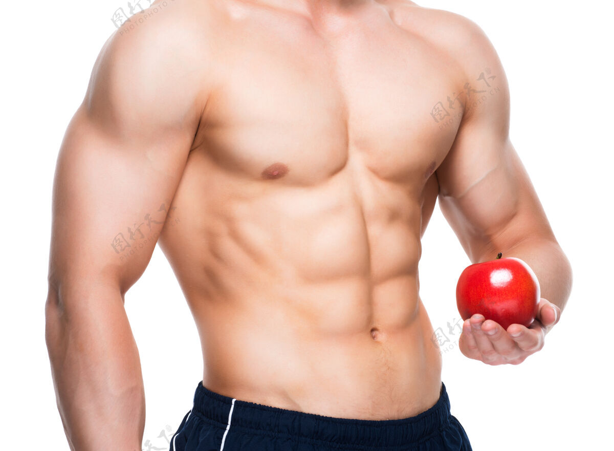 成人身材完美的年轻人手里拿着红苹果胸部肌肉健美