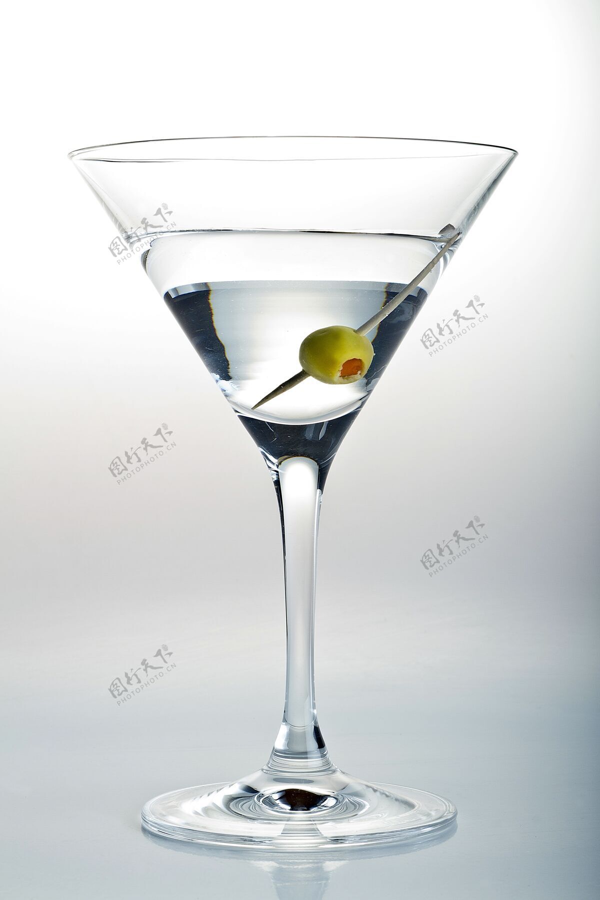 聚会一杯马提尼酒和一个橄榄在白色的垂直镜头人水果有机
