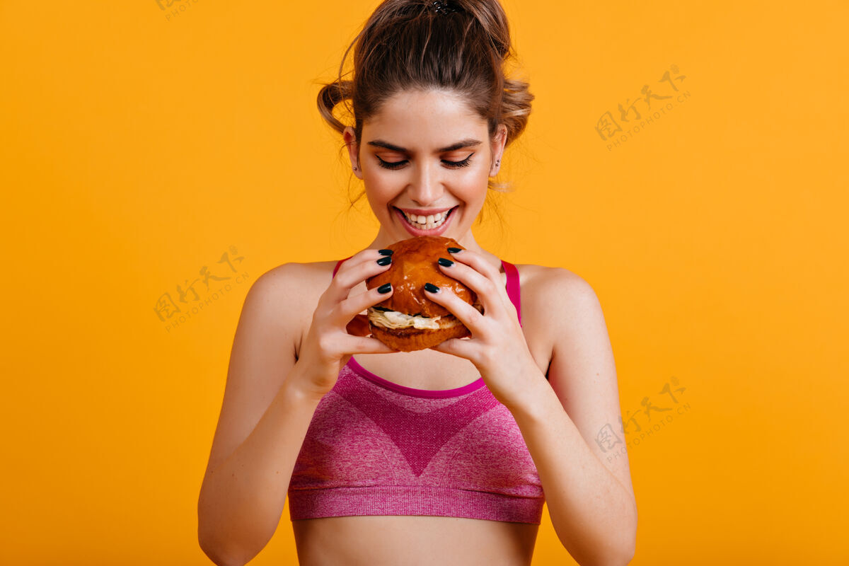 汉堡包微笑的女人吃汉堡面子运动年轻女人