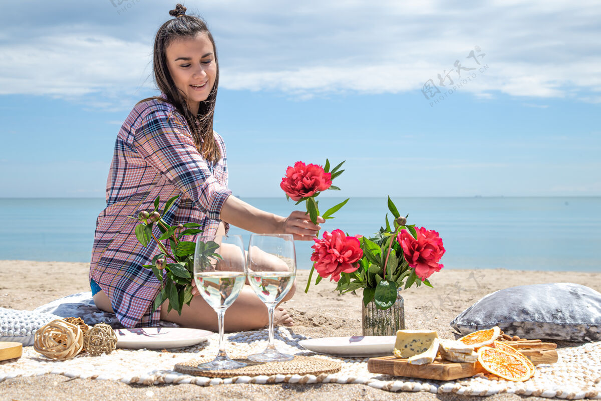 年轻一个女孩在沙滩上休息在沙滩的沙滩上浪漫的野餐暑假的概念美丽大海度假