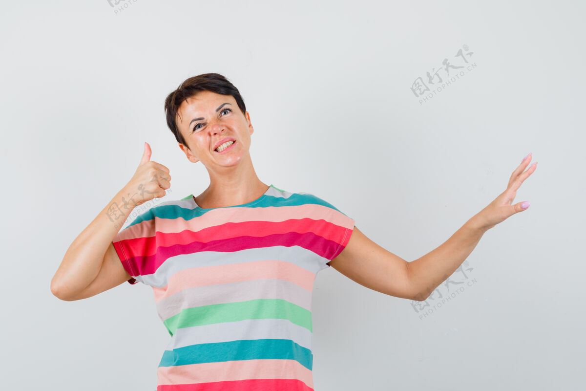 犹豫身着条纹t恤的女性 大拇指朝上 摆出停住的姿势 表情犹豫不决肖像疾病拇指
