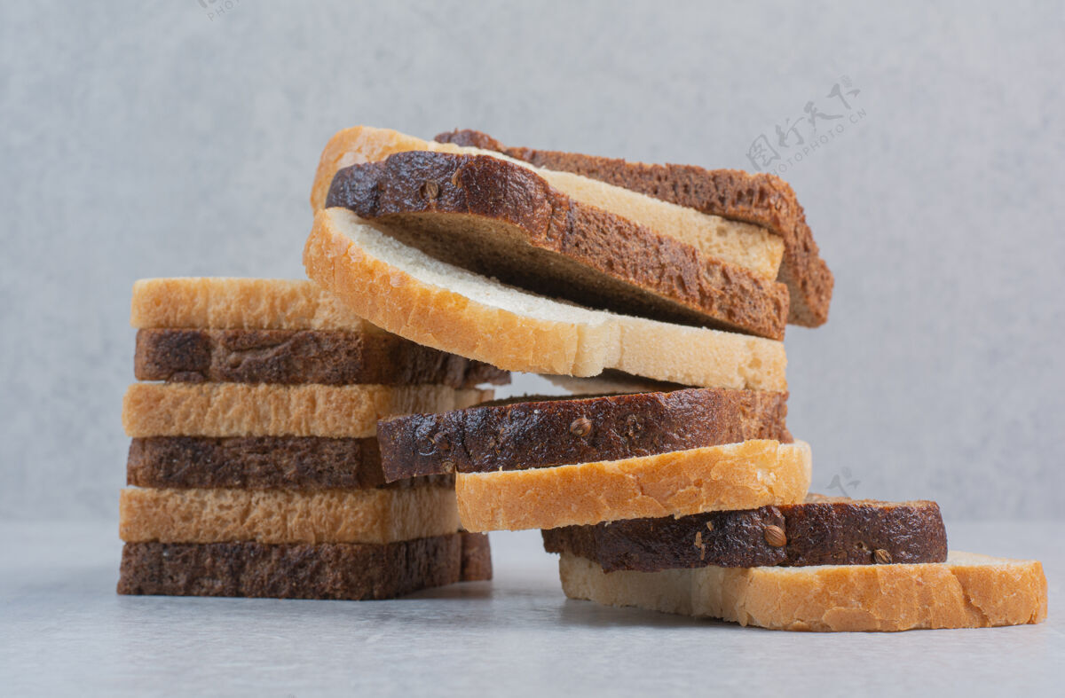 美味新鲜的白色和棕色面包片放在大理石背景上食品切片面包