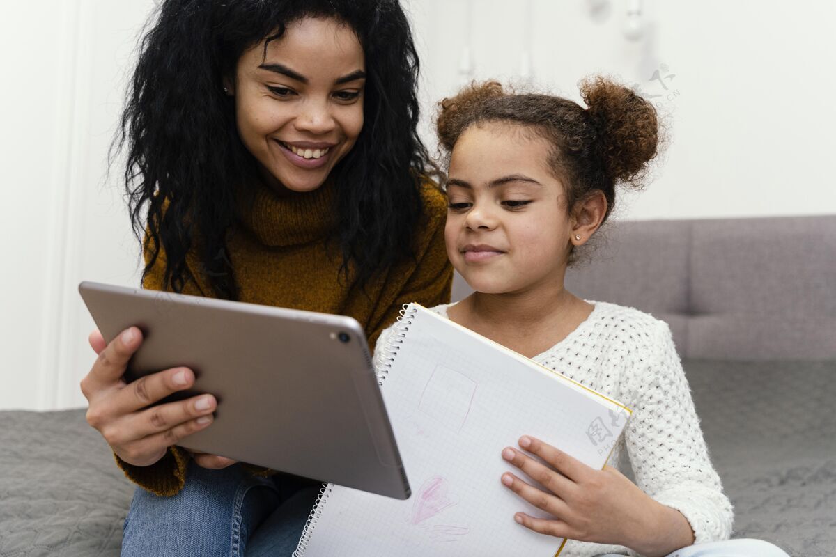 女孩少女帮妹妹使用平板电脑上网上学网络平板电脑在线