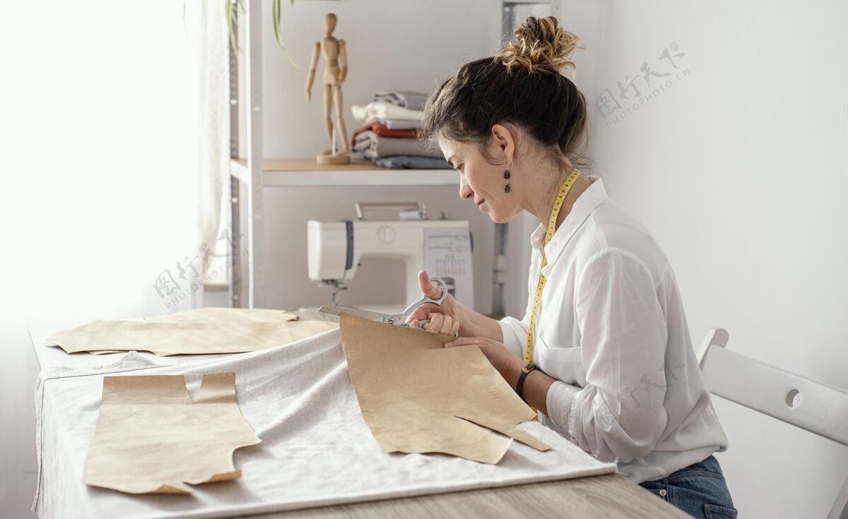 女士女裁缝在工作室工作的侧视图缝纫女裁缝服装