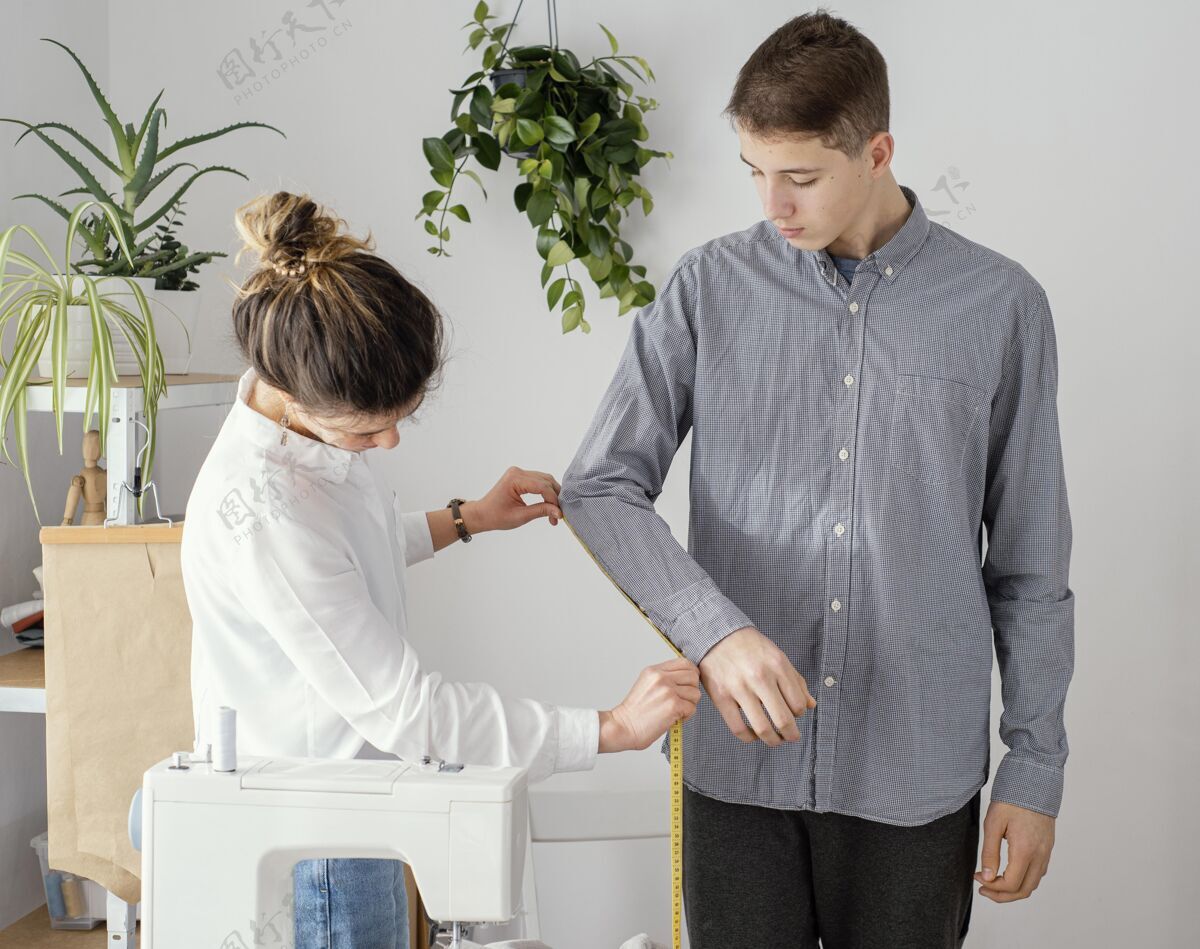 缝纫机女裁缝测量男客户衬衫的侧视图服装师时装师衣服