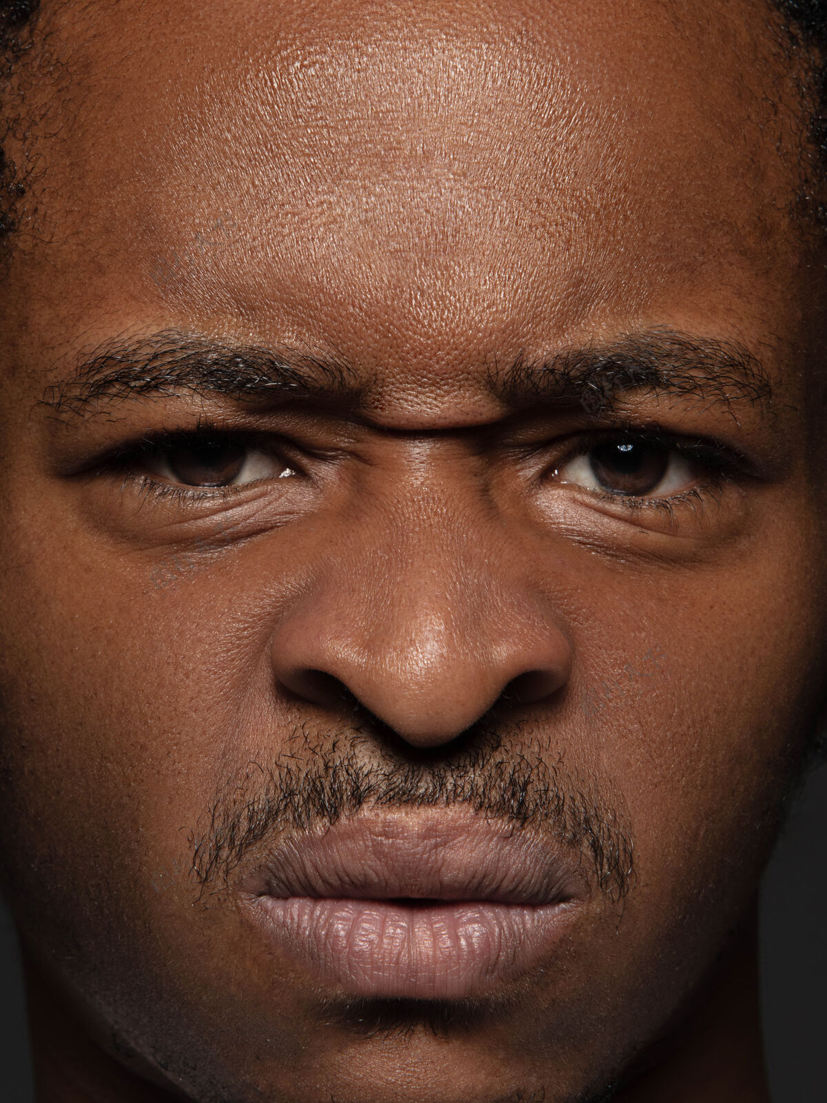 相机年轻而感性的非裔美国人的特写肖像高度细节的男性模特照片 保持良好的皮肤和明亮的面部表情人类情感的概念愤怒时尚立场封闭