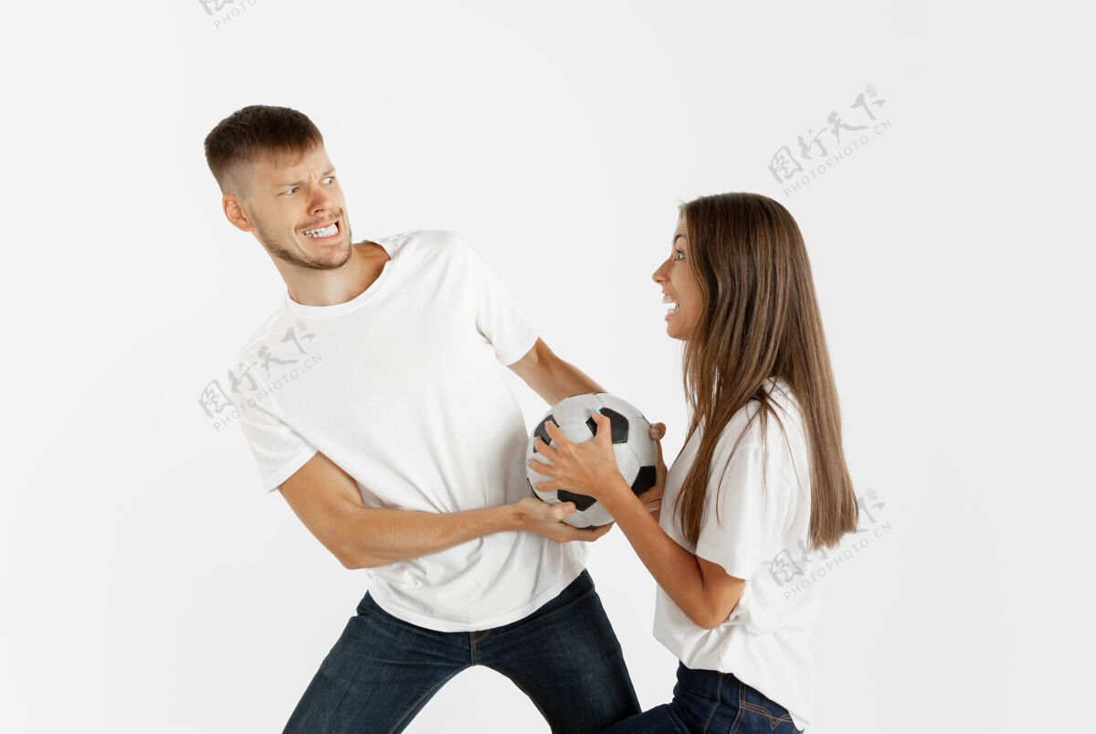 脸在白色工作室背景上的美丽的年轻夫妇足球或足球迷的肖像面部表情 人类情感 广告 运动概念女人和男人跳跃 尖叫 玩得开心惊喜微笑表情