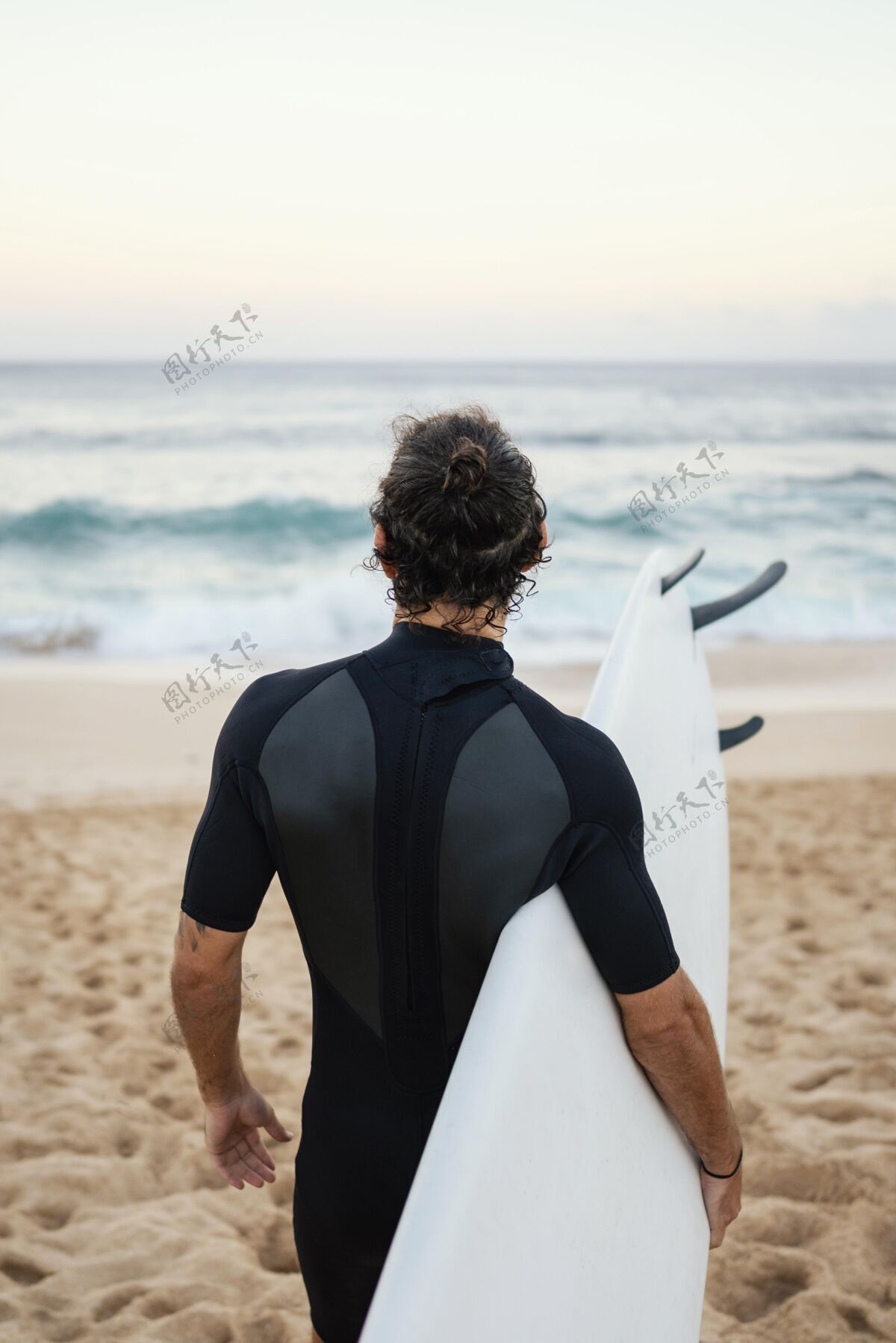 活跃穿着冲浪服在沙滩上行走的人日光热带海洋